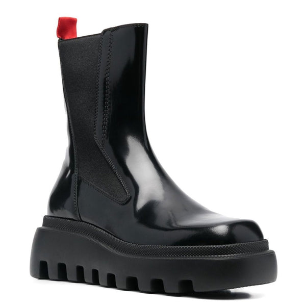 Black leather ankle boots with chunky sole and red detail, perfect for autumn and winter fashion.