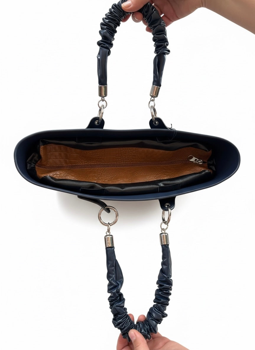 Interior view of a large navy blue handbag with detachable handles and brown lining, perfect for stylish women.